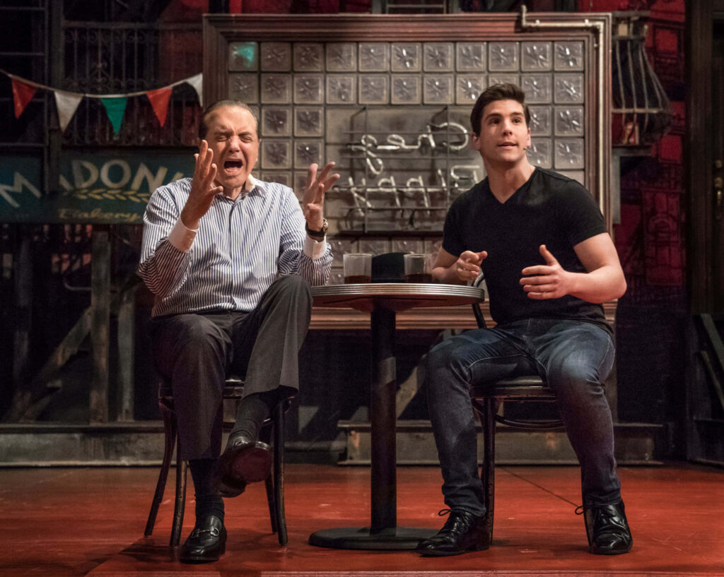 Chazz Palminteri and Adam Kaplan in dramatic conversation on stage with Bronx Tale backdrop Wallpaper