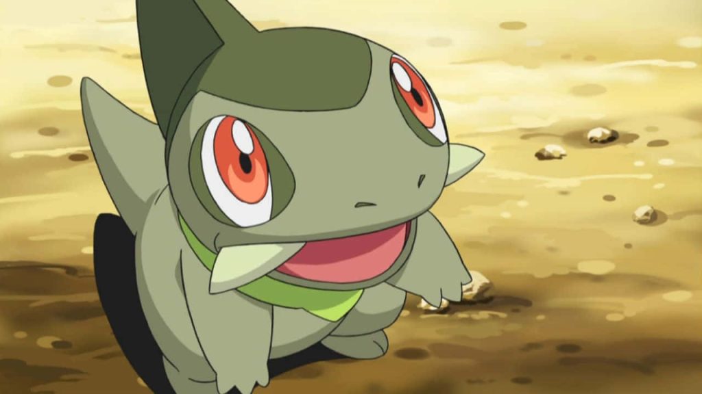 Axew anime wallpaper cheerful Dragon-type Pokémon on sunlit sandy ground bright red eyes