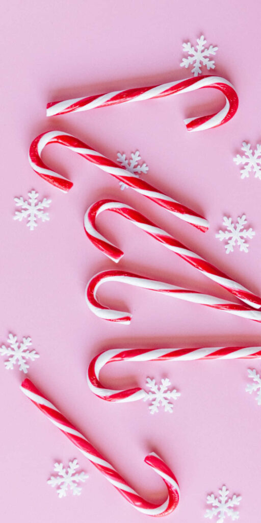 Vibrant Red-and-White Candy Cane Wallpaper on Soft Pink Background