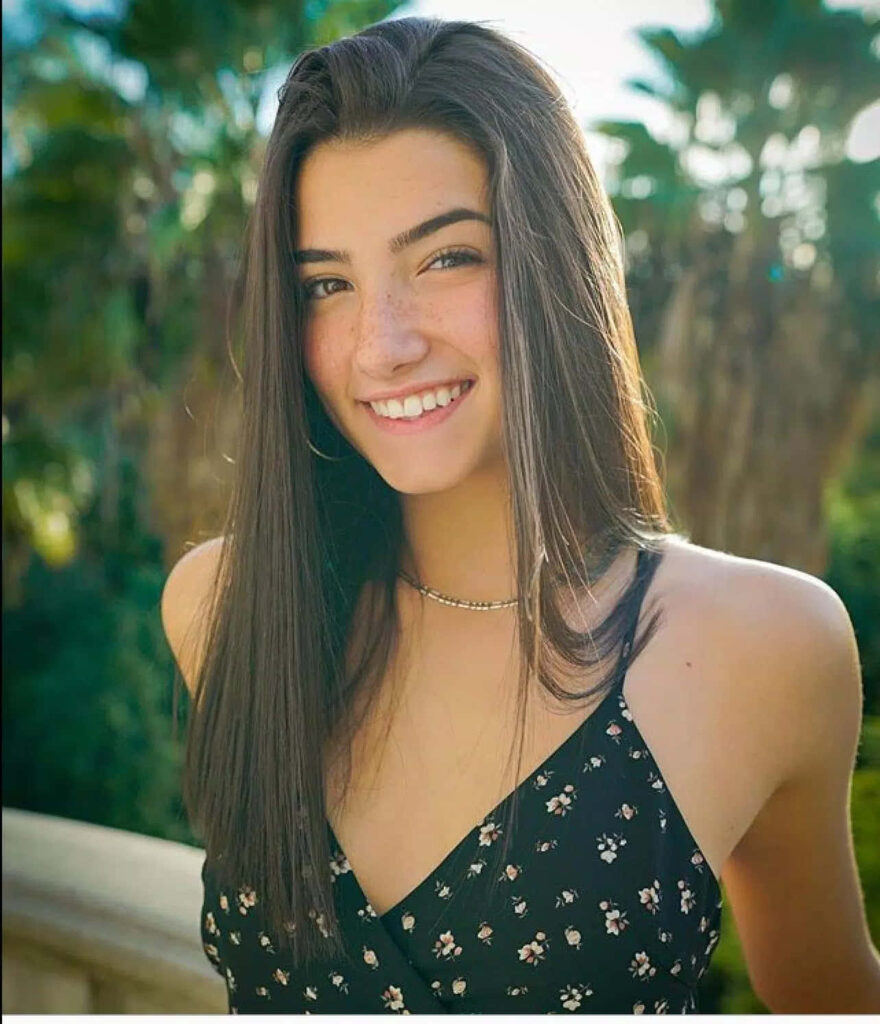 Cheerful Charli D'Amelio Wallpaper: Young Woman Smiling by Palm Trees