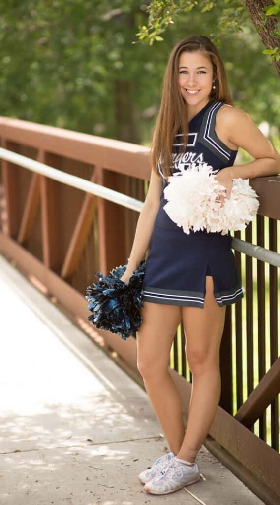 Cheerful Cheerleader on Bridge - Navy Uniform Wallpaper Background