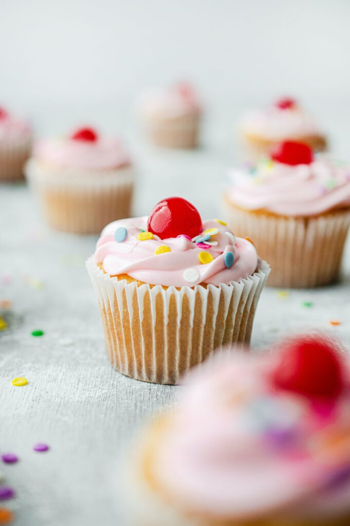Cheerful Cupcake Wallpaper: Pink Frosting & Colorful Confetti Background