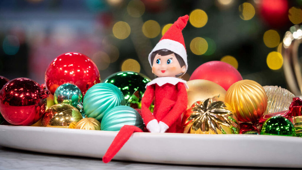 Cheerful Elf Surrounded by Colorful Christmas Ornaments - Festive Decor Wallpaper
