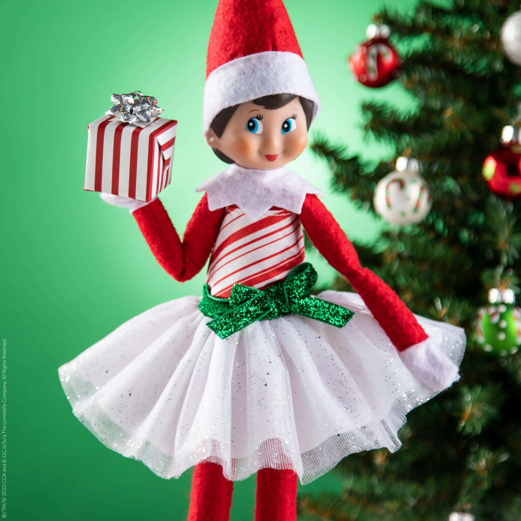 Joyful Elf on the Shelf by Christmas Tree with Present - Holiday Cheer! Wallpaper
