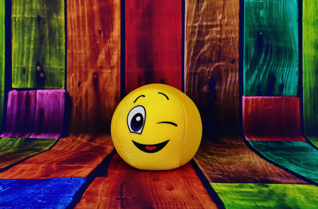 Colorful Wooden Planks Frame a Cheerful and Winking Emoji Wallpaper