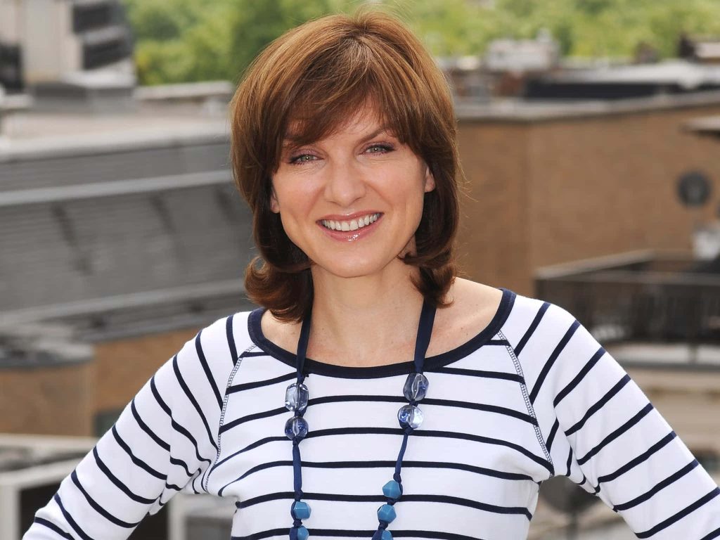 Cheerful portrait of British journalist Fiona Bruce in striped top with blue necklace outdoors Wallpaper