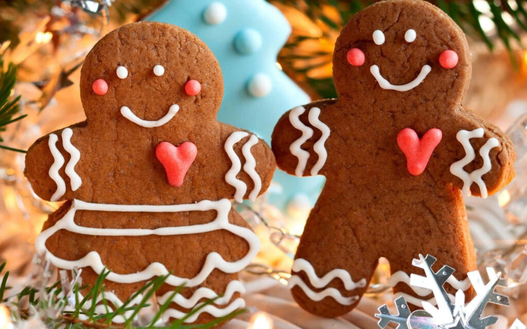 Cheerful Gingerbread Cookies Wallpaper with Holiday Lights & Decorations