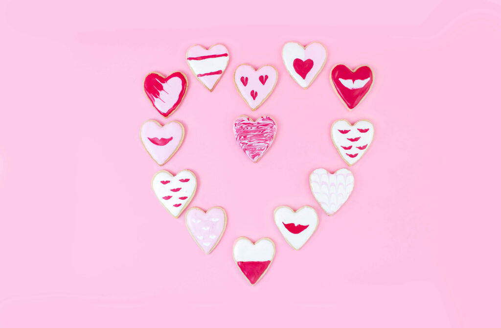 Cheerful Heart-Shaped Cookie Wallpaper in Pink Background