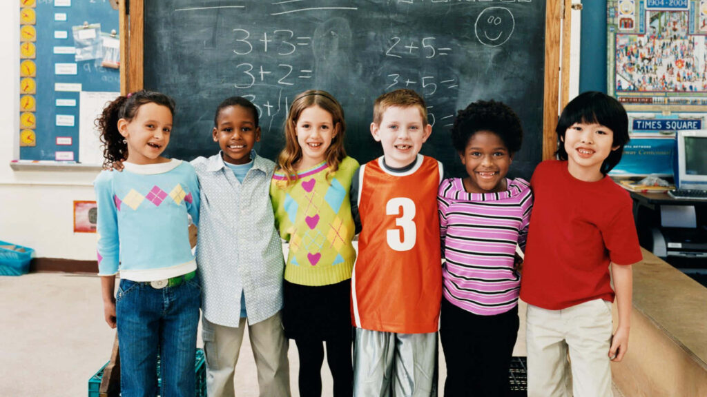 Cheerful children wallpaper six smiling kids in colorful classroom with chalkboard math problems