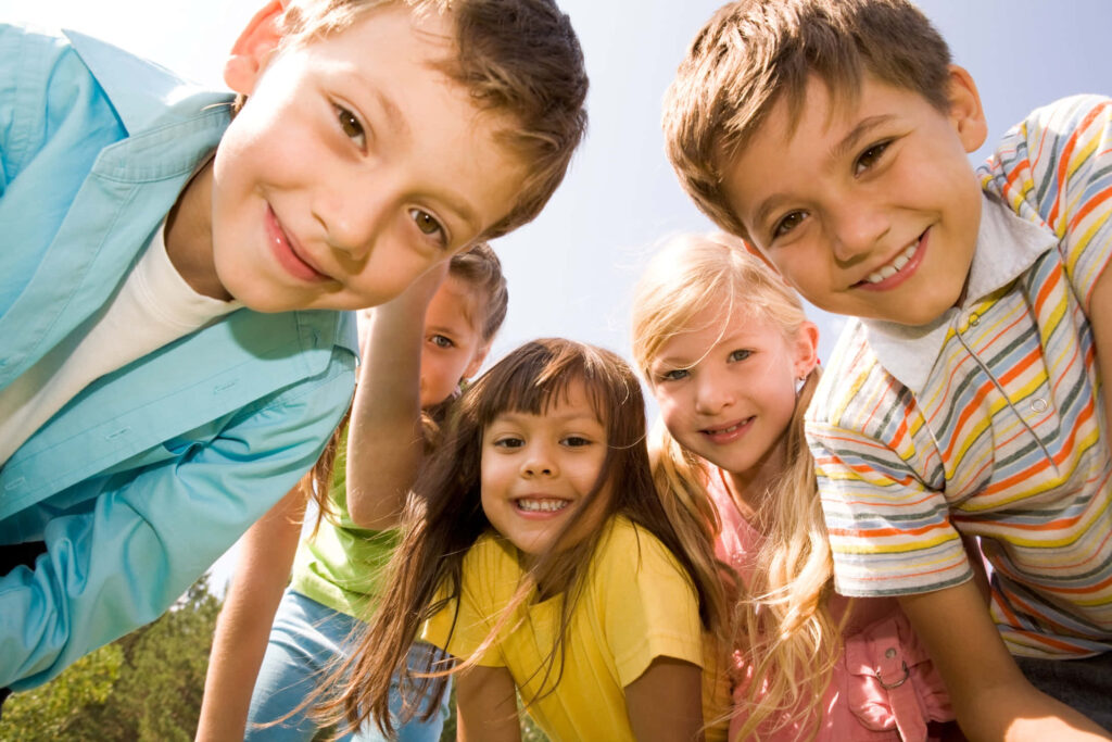 Smiling children playing outdoors on a sunny day bright colorful kids wallpaper background