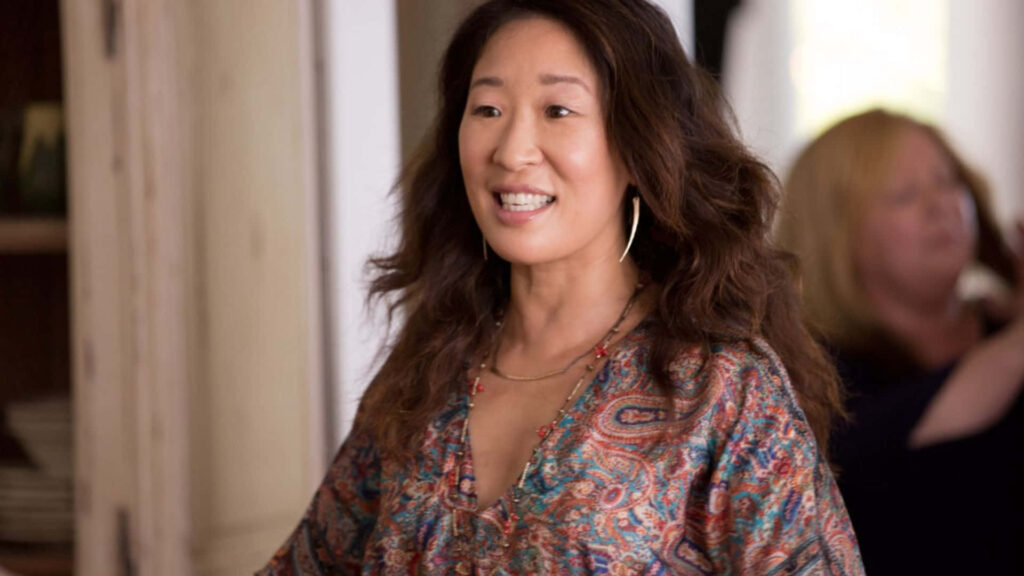 Cheerful Killing Eve Moment: Character Smiling in Vibrant Outfit Wallpaper