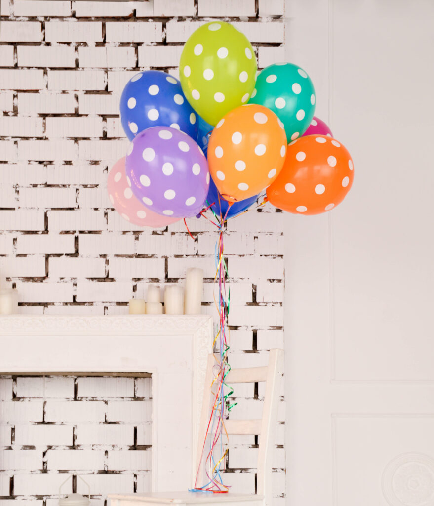 Festive Polka Dot Balloons on Rustic White Brick Background - Wallpaper