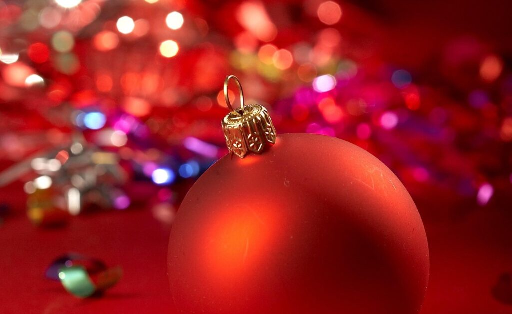 Close-Up Red Christmas Ornament with Blurred Colorful Lights Background Wallpaper