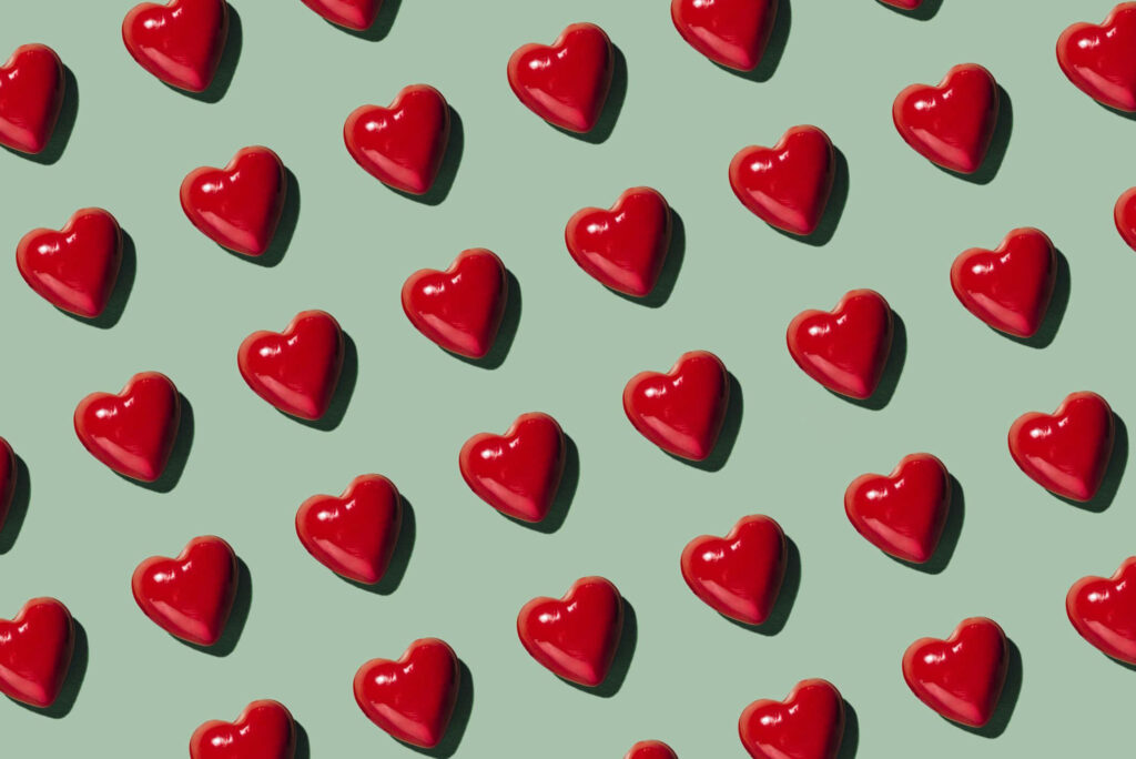 Bright Red Heart Wallpaper on Light Green Background - Cheerful Design