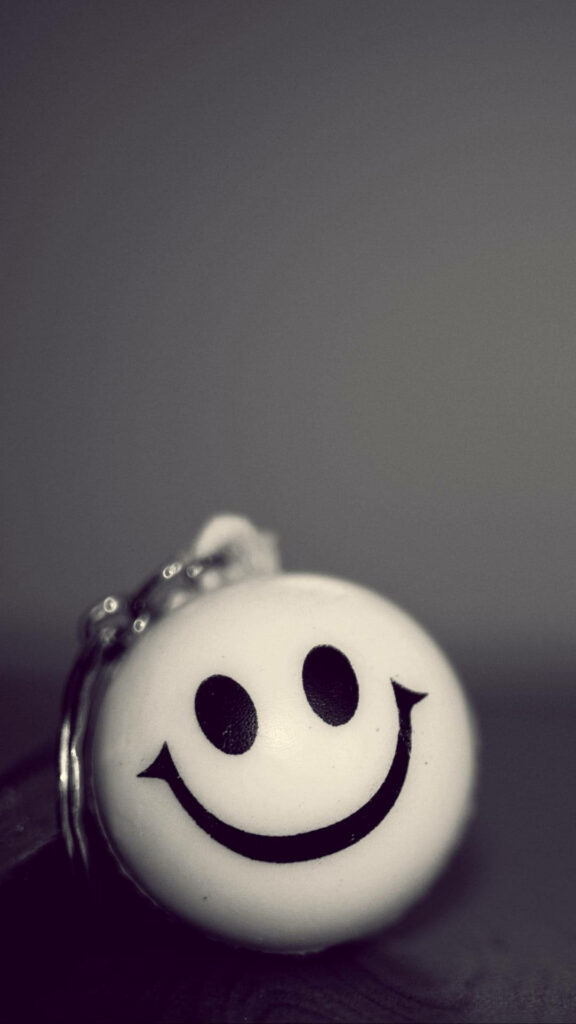Smiley Face Keychain Close-Up: Nostalgic Minimalist Wallpaper