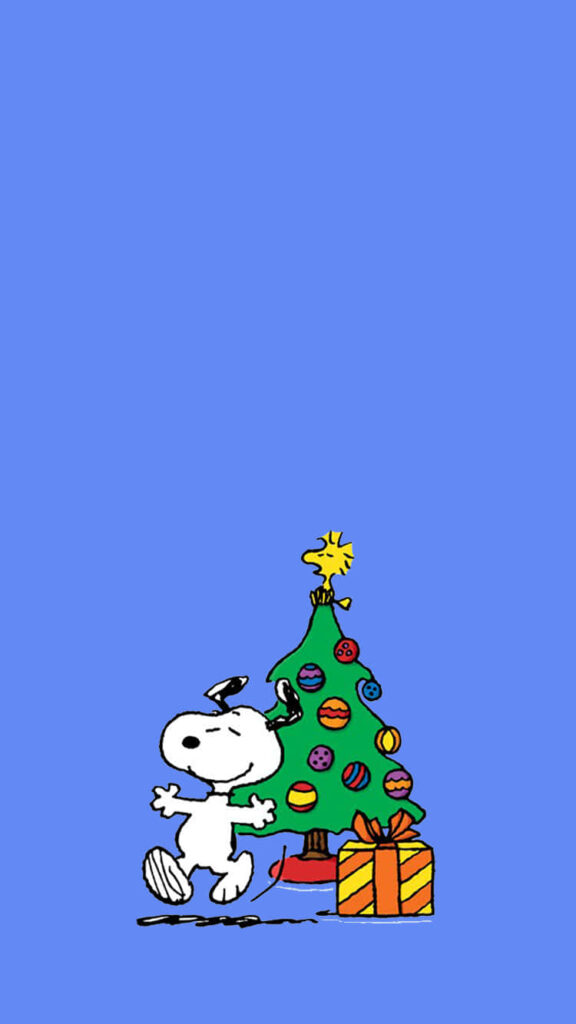 Cheerful Snoopy Hugs Festive Christmas Tree with Colorful Ornaments Wallpaper