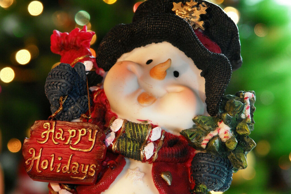 Cheerful Snowman Decorates Festive Wallpaper with Christmas Lights