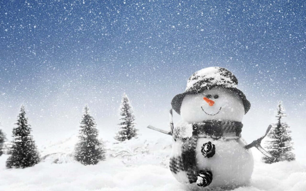 Cheerful Snowman with Carrot Nose in Snowy Pine Tree Landscape Wallpaper