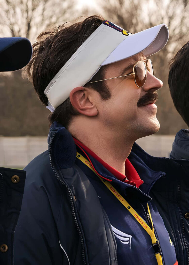 Vibrant Ted Lasso Wallpaper: Cheerful Icon in Visor & Sunglasses
