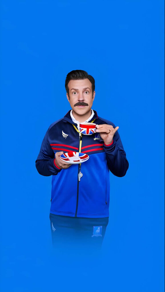 Cheerful Ted Lasso Wallpaper on Solid Blue Background