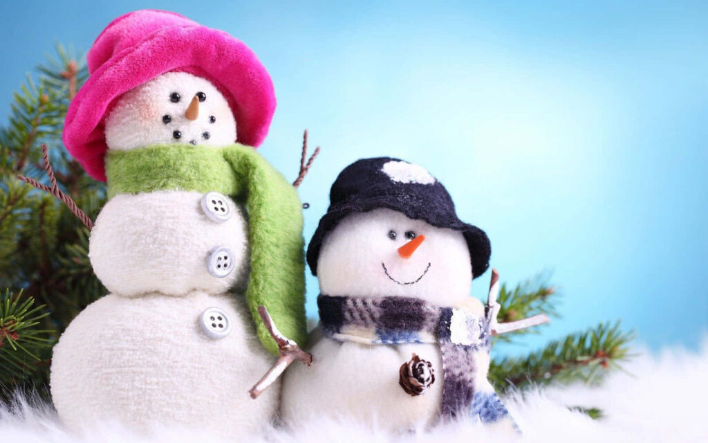 Cheerful Winter Scene: Adorable Snowmen in Cozy Scarves & Snowy Pines Wallpaper