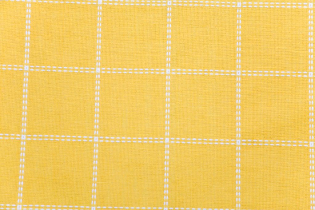 Yellow fabric texture wallpaper with white stitched grid pattern and woven textile details