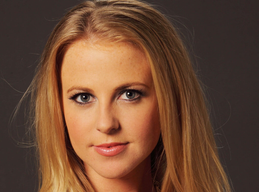 Close-up portrait of Chelan Simmons with blonde hair and blue eyes on dark neutral background wallpaper