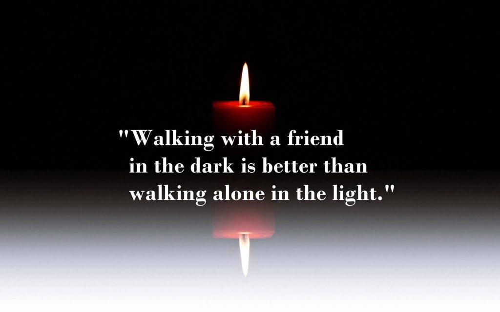 Warm glowing red candle on dark background with friendship quote wallpaper background design