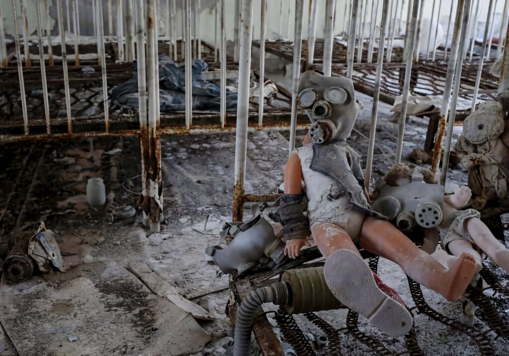 Abandoned dolls with gas masks in decaying cribs in eerie Chernobyl disaster room background Wallpaper