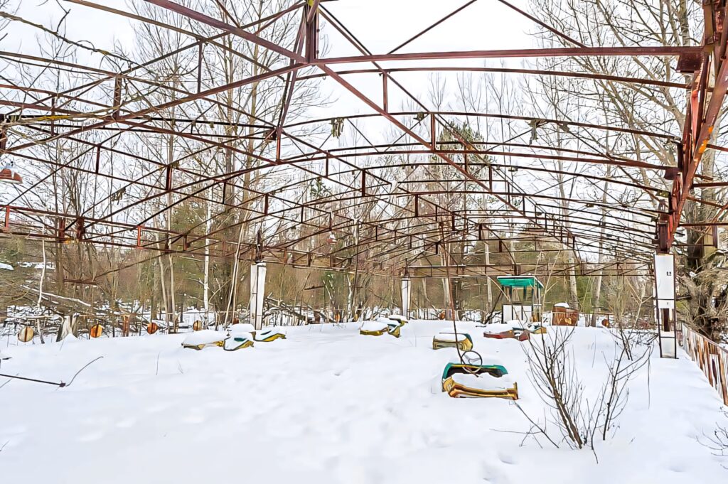 Rusty metal frame of abandoned Chernobyl structure in snowy forest evokes eerie desolation Wallpaper