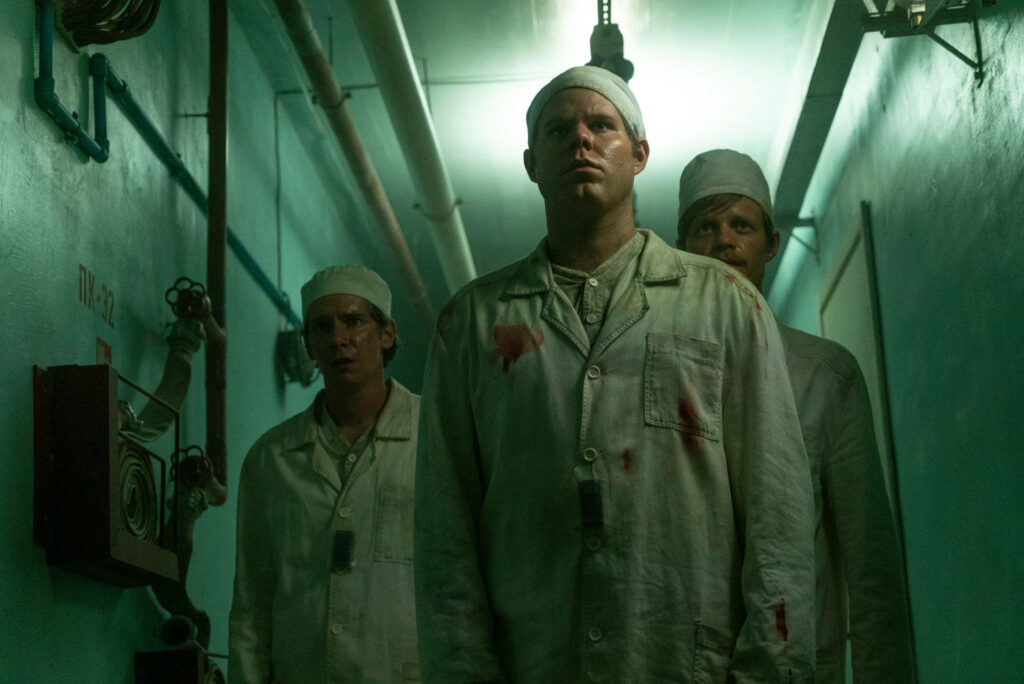 Chernobyl HBO wallpaper three men in stained protective suits walking dim industrial corridor tense atmosphere