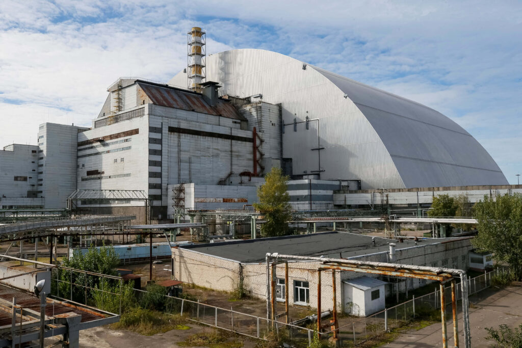 Chernobyl nuclear plant wallpaper with sarcophagus dome and industrial pipes in muted gray tones