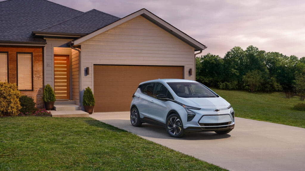 Sleek Chevrolet Electric Car Wallpaper in Modern Suburban Setting