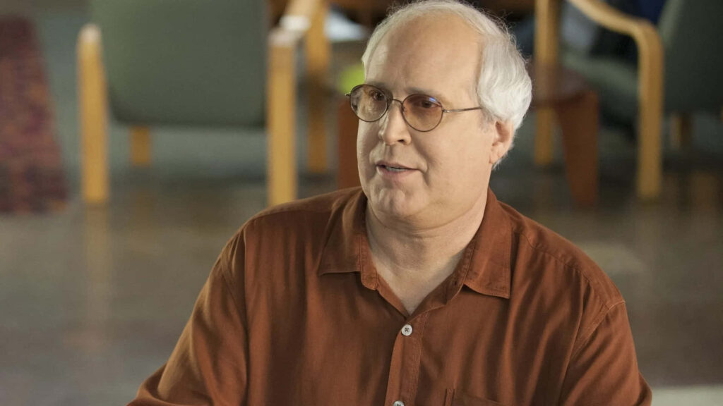 Chevy Chase candid portrait in rust shirt and glasses with soft natural light wallpaper background