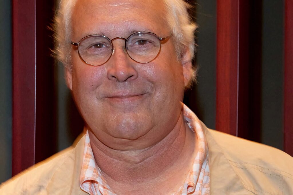 Chevy Chase portrait wallpaper warm red green background friendly smile casual jacket