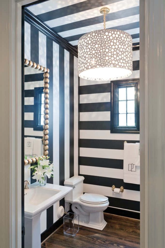 Powder room with black white stripes perforated pendant beaded mirror pedestal sink dark wood floor Wallpaper