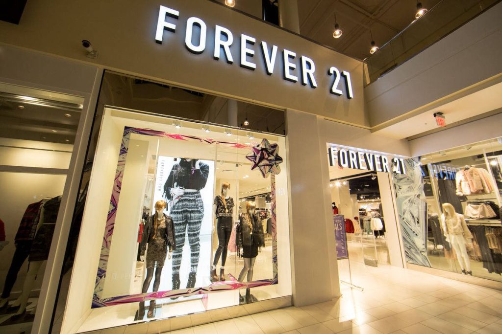 Chic Forever 21 boutique window display with stylish mannequins and bright modern lighting Wallpaper