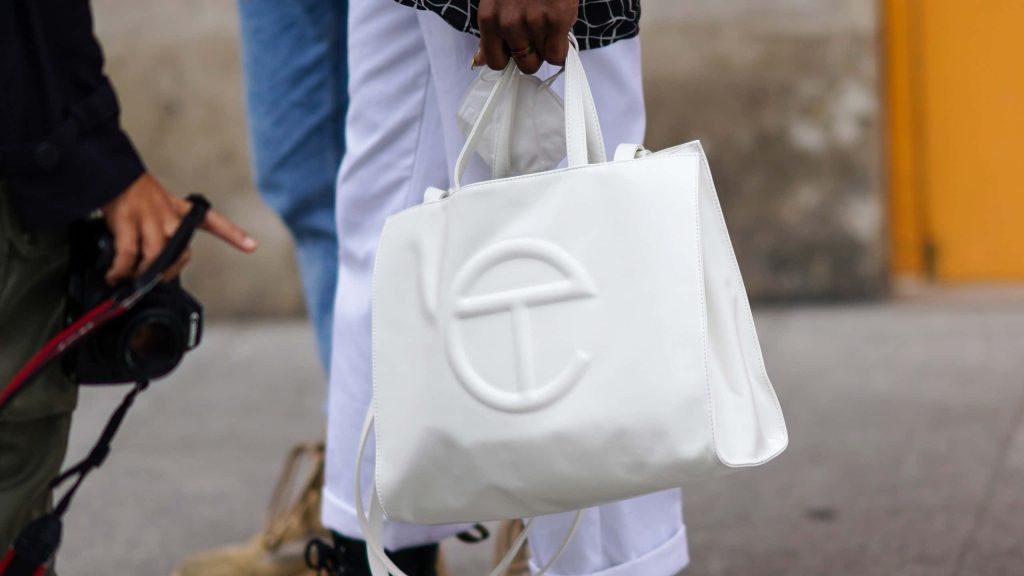 Chic white Telfar handbag wallpaper showing embossed logo in bright daylight street fashion shot