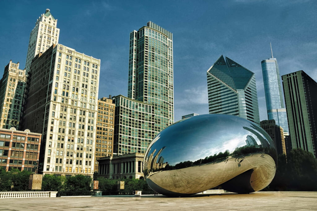 Cloud Gate sculpture reflecting Chicago skyline with modern and historic skyscrapers in daylight Wallpaper