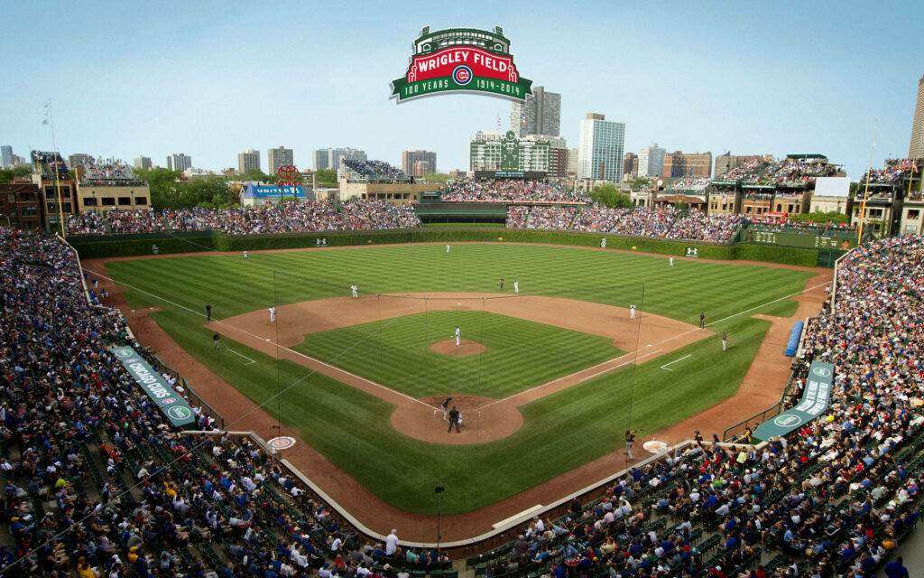 Chicago Cubs game at Wrigley Field vibrant field packed stands iconic sign clear blue sky wallpaper