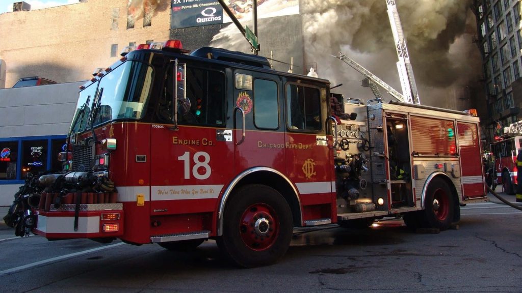 Chicago Fire Department Engine 18 truck on city street with smoke near Quiznos and Wabash sign Wallpaper