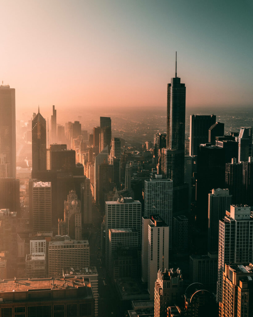 Aerial view of Chicago skyline at sunset with golden light and towering modern skyscrapers Wallpaper