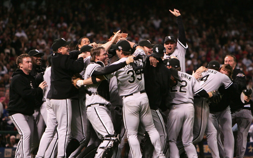 Chicago White Sox players celebrate victory on field wearing black and white uniforms in stadium Wallpaper
