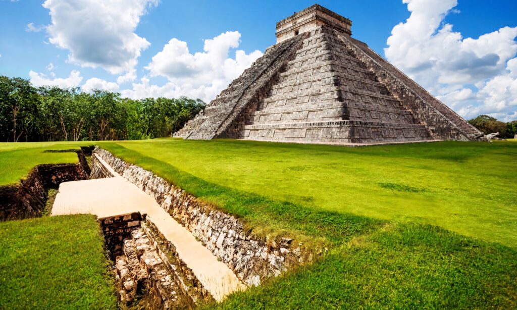 Chichén Itzá pyramid ancient Mayan ruins bright blue sky green grass detailed stone carvings wallpaper