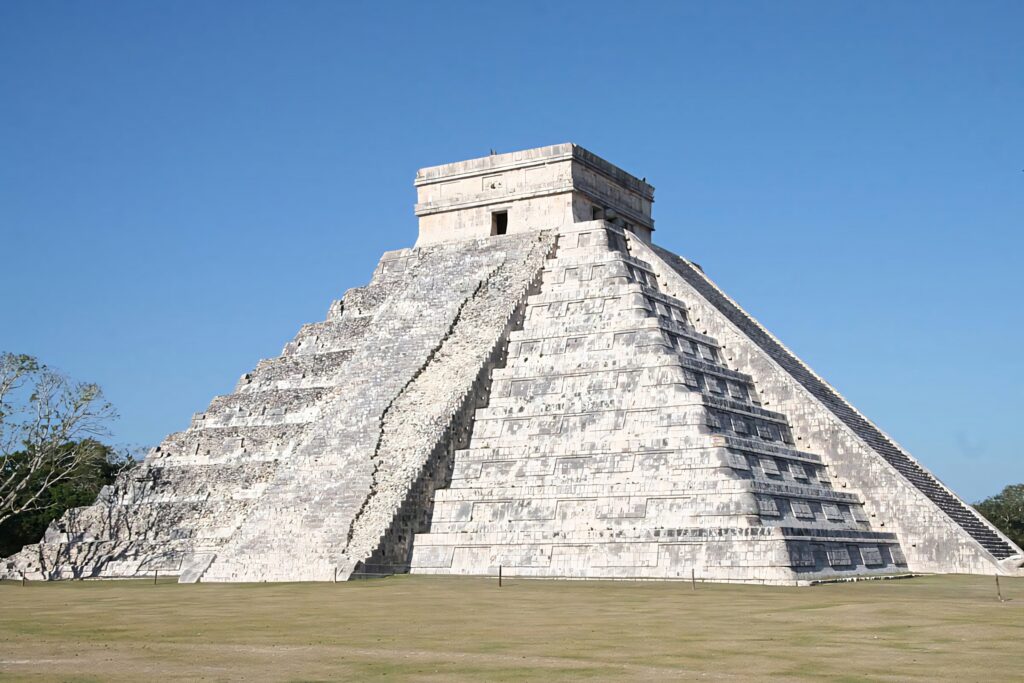Chichén Itzá pyramid under bright blue sky with detailed stone steps and sharp sunlit shadows Wallpaper