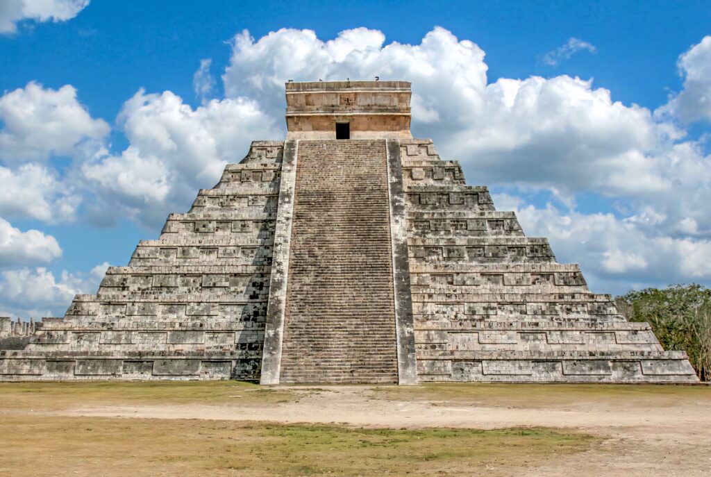 Chichen Itza Wallpaper: Majestic Pyramid Against Blue Sky Background
