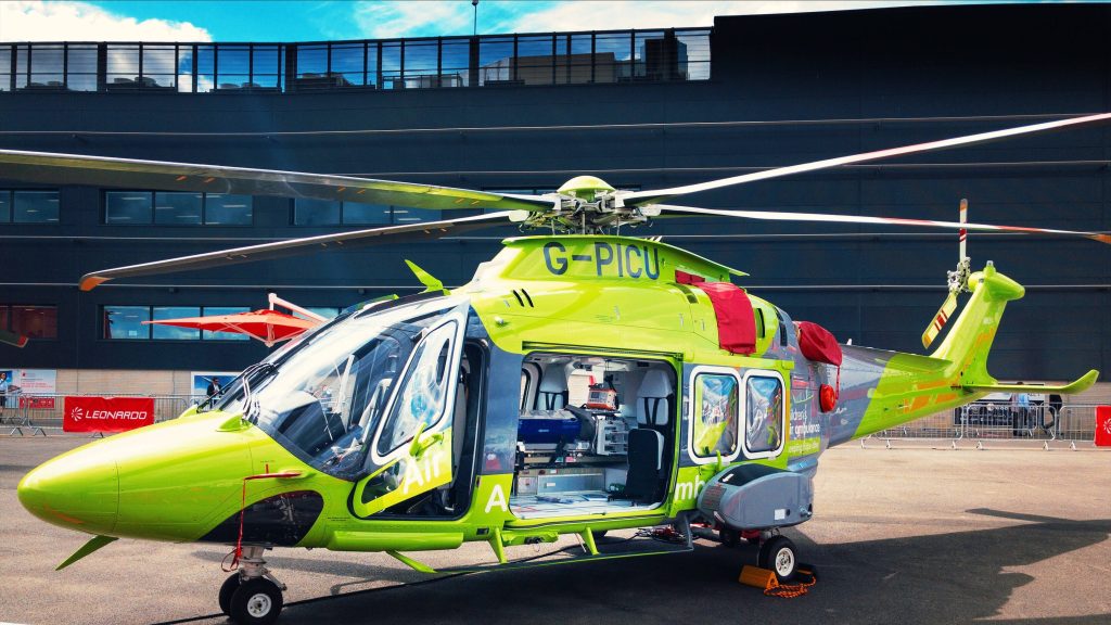 Children's Air Ambulance Leonardo AW169 neon green medical helicopter parked bright daylight Wallpaper