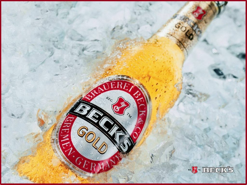Chilled Beck's Gold beer bottle in crushed ice with condensation premium wallpaper background
