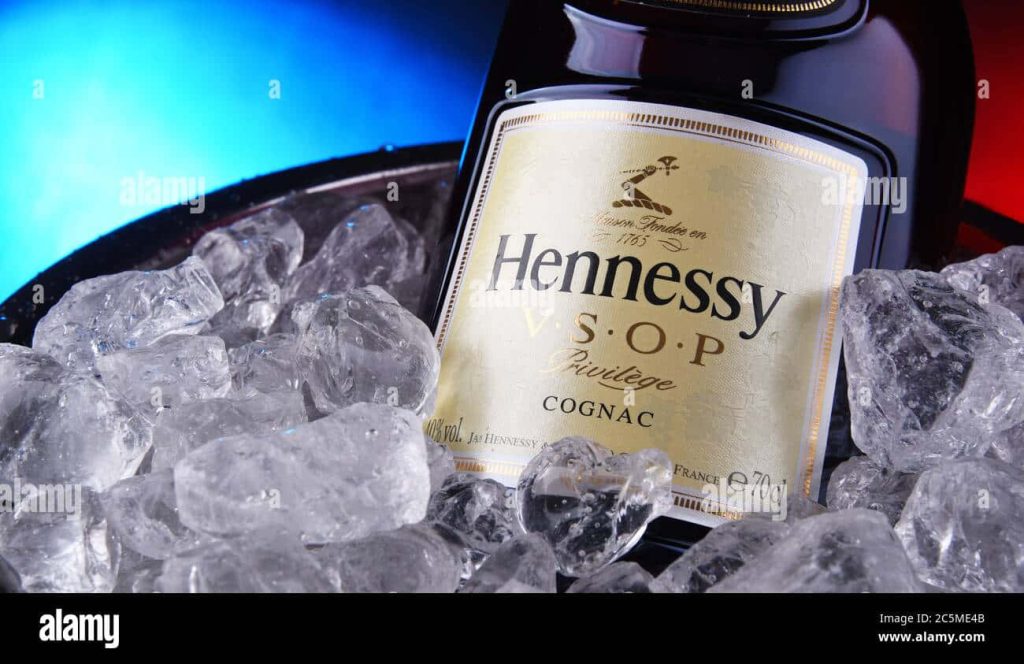 Chilled Hennessy V.S.O.P Privilège Cognac bottle in ice bucket with blue red gradient background Wallpaper
