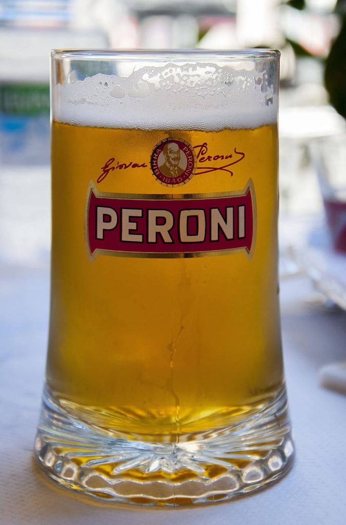 Close-up of chilled Peroni beer mug with golden lager in bright natural light background Wallpaper